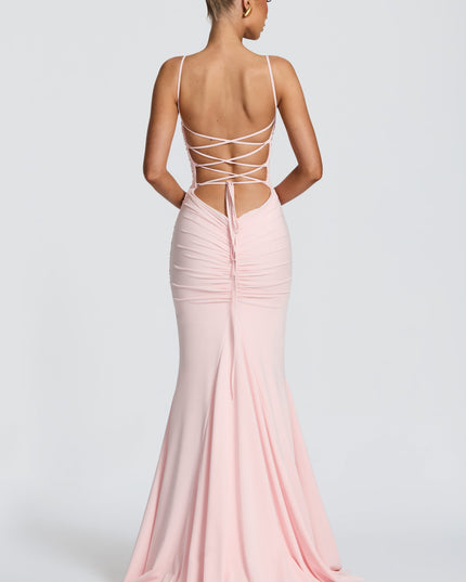 Back view of blush pink ruched maxi dress with lace-up open back and long tie detail