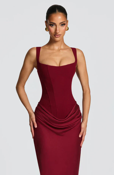 Close front view of burgundy square neck corset maxi dress with defined seams and draped waist