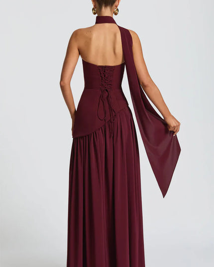 Back view of burgundy halter maxi dress with lace-up corset back and flowing skirt