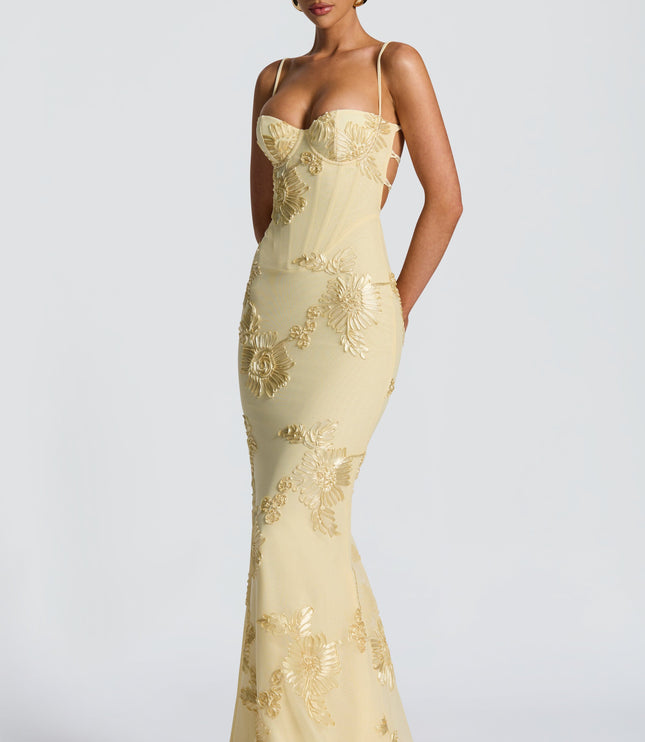 Butter yellow lace maxi dress with floral appliqué and sweetheart bustier bodice, angled front view