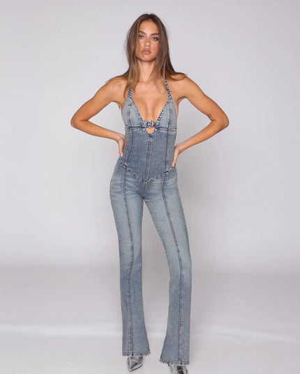 Front view of a light blue halter denim jumpsuit with deep V neckline and flared legs