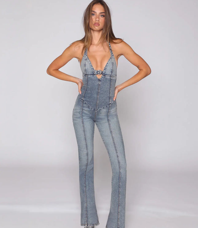 Front view of a light blue halter denim jumpsuit with deep V neckline and flared legs