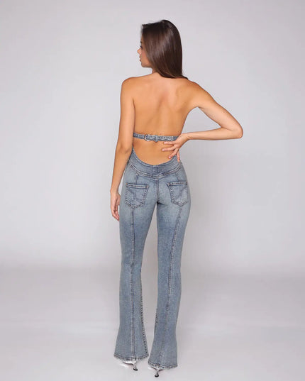Rear view of a light blue halter denim jumpsuit with open back and flared legs