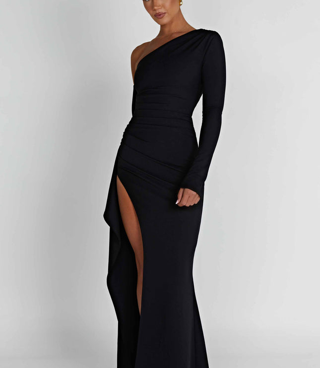 Angled view of a black one-shoulder long sleeve maxi dress with a side slit and subtle draping.