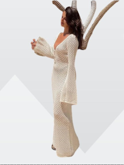 Side profile of a white long sleeve crochet maxi dress with a deep V-neck, showcasing the full length and bell sleeves.