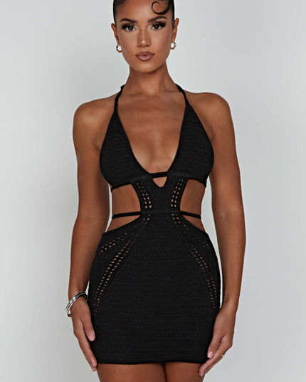 Front view of the black crochet plunge halter neck mini dress with side cut-outs, a woman with dark hair.