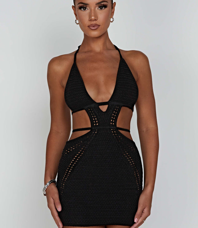 Front view of the black crochet plunge halter neck mini dress with side cut-outs, a woman with dark hair.