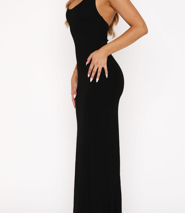 Side profile of the black halter scoop neck maxi dress, highlighting the elegant drape and form-fitting style.
