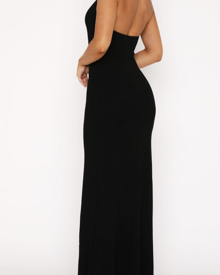 Back view of the black halter scoop neck maxi dress, featuring the open back design and long skirt.
