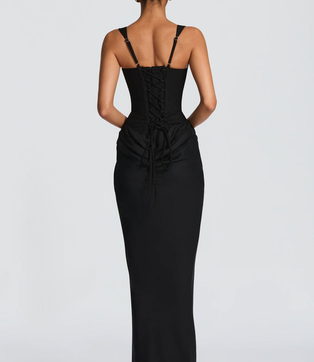 Back view of the black square neck draped corset maxi dress, featuring a detailed lace-up corset back.