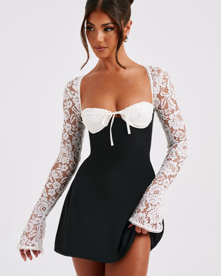 Front view of a women's black mini dress with white lace long sleeves and a tie-front bust detail.