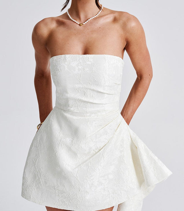 Close-up front view of the white floral strapless mini dress, highlighting the textured fabric and ruched bodice.