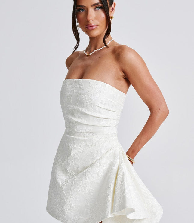 Side angle of the white floral strapless mini dress, showcasing the elegant drape of the skirt and fitted bodice.