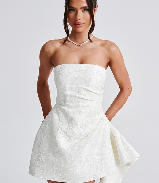 Front view close-up of the white floral strapless mini dress, emphasizing the textured pattern and neckline.