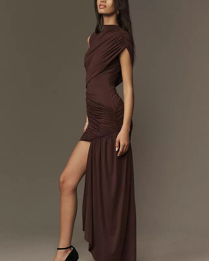 Side profile of a brown ruched asymmetrical mini maxi dress, showcasing the high leg slit and flowing skirt detail.