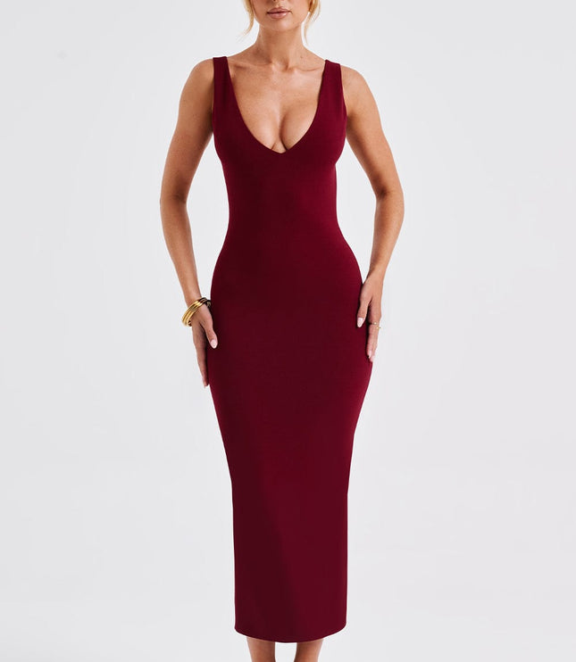 Form-fitting women's burgundy plunge neck midi dress with a low back design, styled with clear heels.