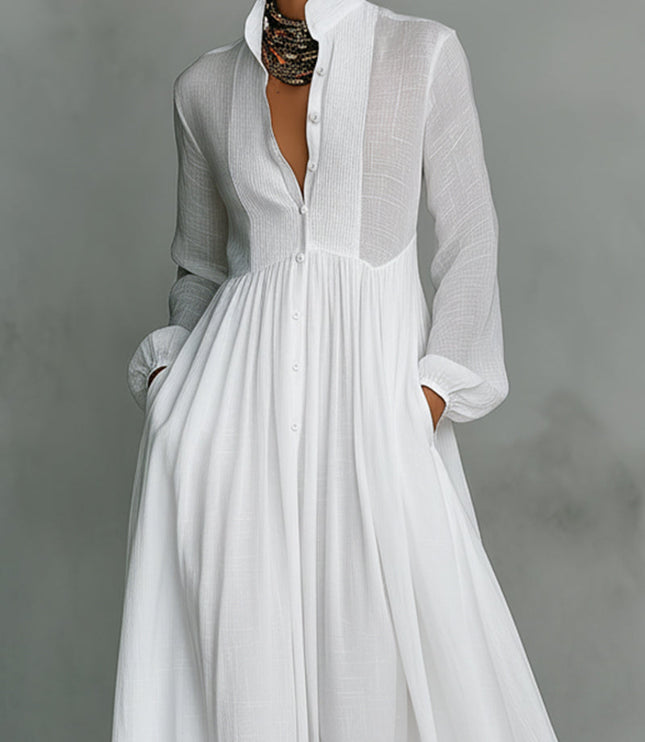 Close-up of the white stand collar jumpsuit, showing button-down front, pleated bodice detail, and lantern sleeves.