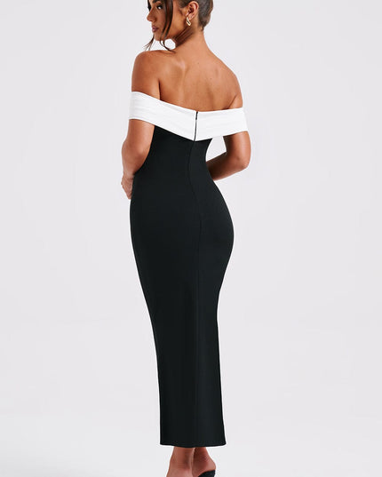 Back profile of women's black and white off-shoulder cocktail midi dress, showing the fitted design and black heels.