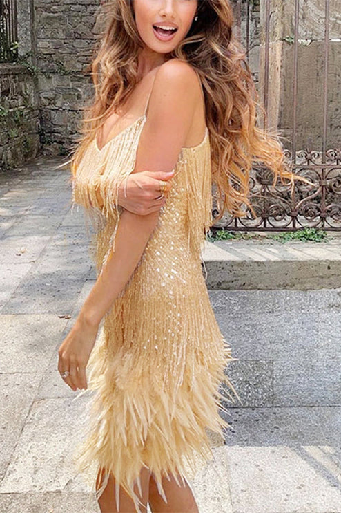 Side profile of a woman wearing a gold sequin fringe mini dress with feather trim, for a cocktail event.