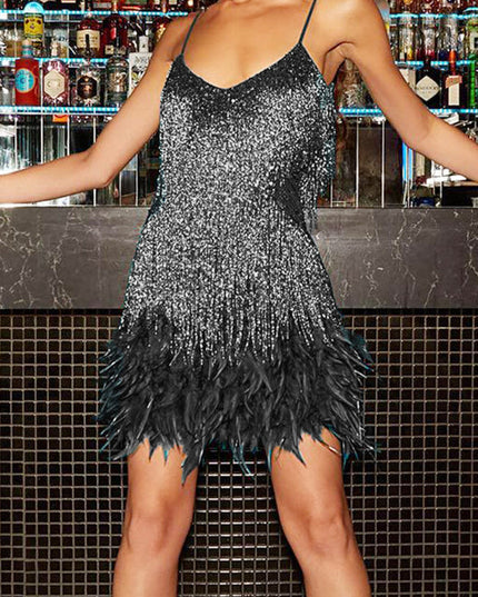 Front view of a woman in a dazzling black and silver sequin fringe feather mini dress, for evenings.