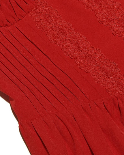 Detail shot of the red fabric of the mini dress, showing the intricate lace trim and vertical pleats on the bodice.