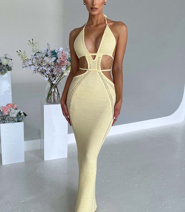 Front view of a women wearing a light yellow crochet knit plunge halter maxi dress, featuring a fitted silhouette and cut-out details.
