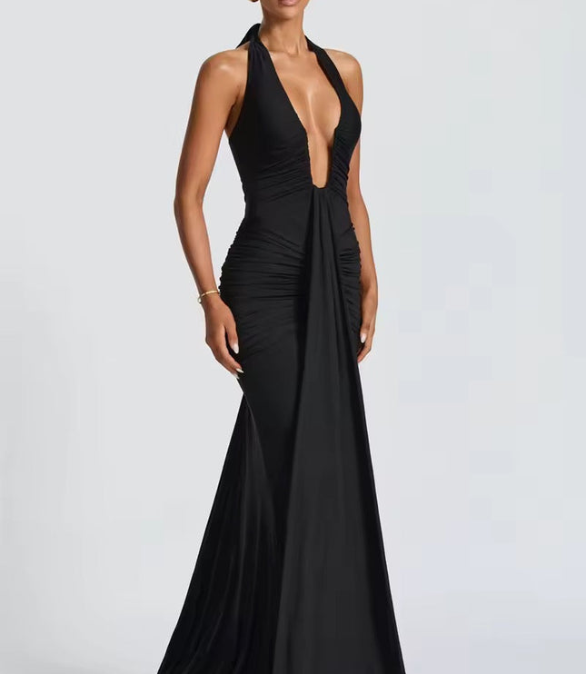 Side profile of a black deep V halter ruched mermaid maxi dress, highlighting the flowing skirt and ruching.