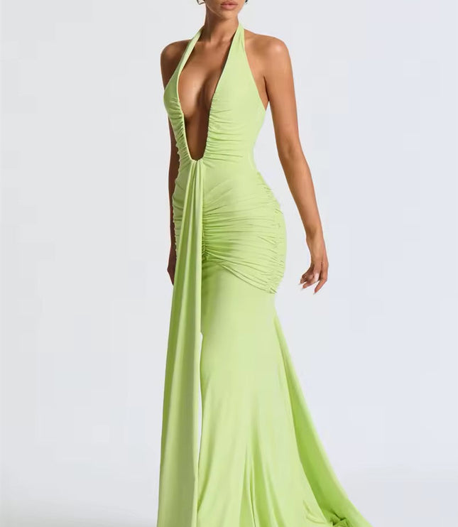 Side view of a light green deep V halter ruched mermaid maxi dress, displaying the flowing mermaid skirt and ruched bodice.