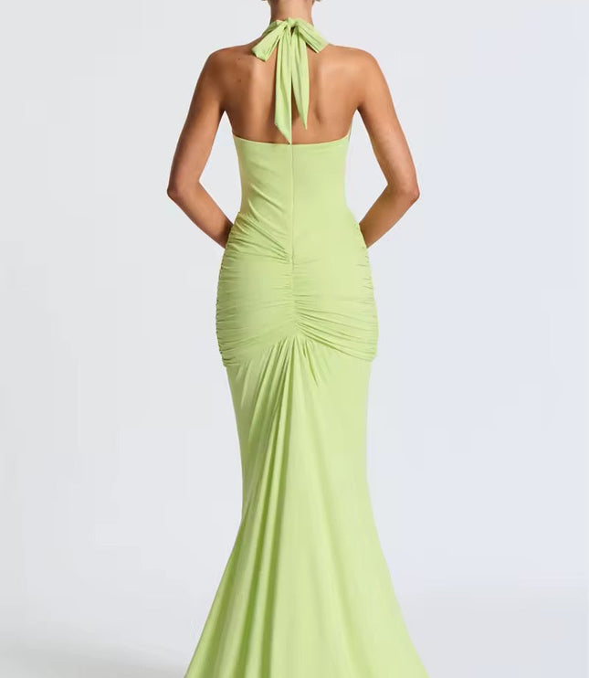 Back view of a light green deep V halter ruched mermaid maxi dress, showing the tied halter neck and ruched back detailing.