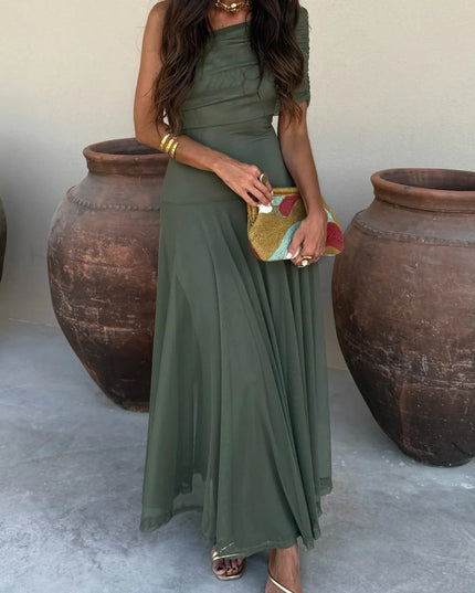 Women's olive green drape one shoulder mesh maxi dress, styled with gold sandals and a colorful clutch.