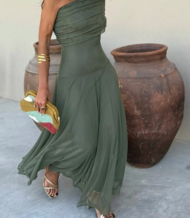 Flowing olive green one-shoulder mesh maxi dress with draped bodice, paired with gold heels and clutch.
