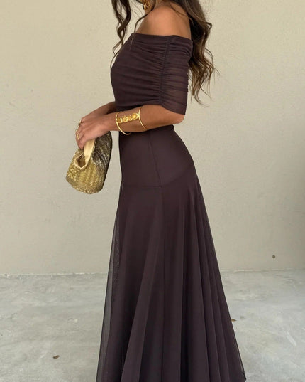 Full side view of a women's chocolate brown off-the-shoulder mesh maxi dress, showcasing the flowing skirt.
