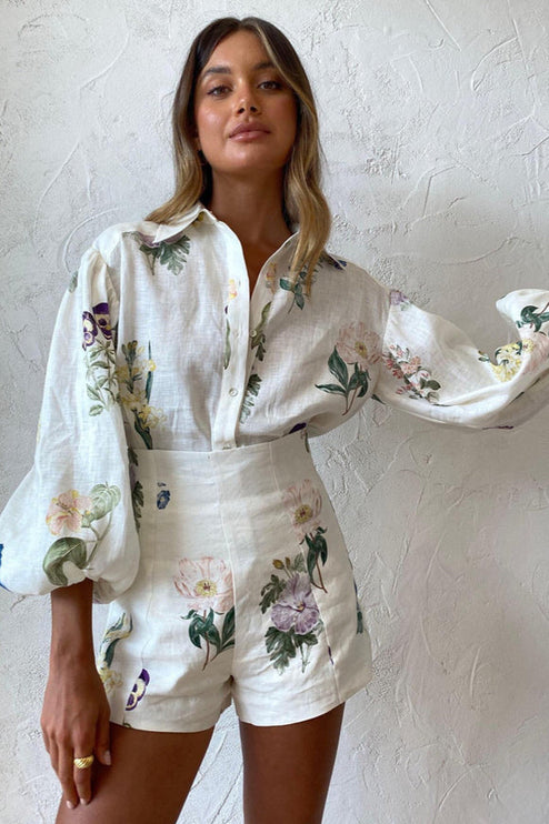 Frontal view of women's white linen floral short set, emphasizing the elegant balloon sleeves and high-waisted shorts.