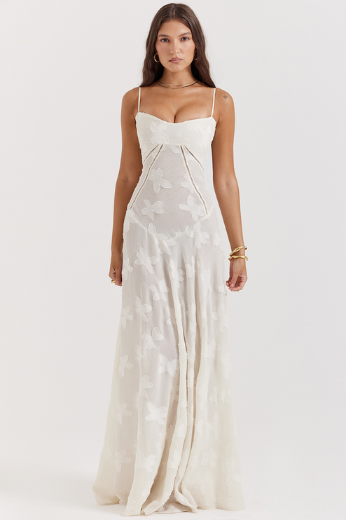 Front view of a white floral corset maxi dress with a sweetheart neckline, thin straps, and a delicate butterfly- floral pattern.