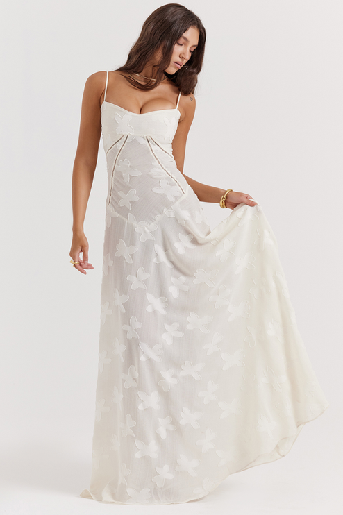 Front view of a white floral corset maxi dress with a sweetheart neckline, thin straps, and a full skirt with butterfly- floral details.