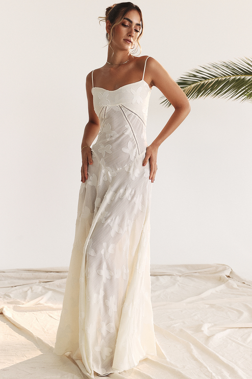 Front view of a white floral corset maxi dress with delicate spaghetti straps and butterfly embroidery.