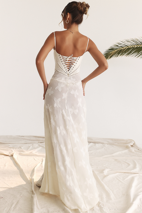Back view of a white floral corset maxi dress featuring a detailed lace-up back and butterfly pattern.