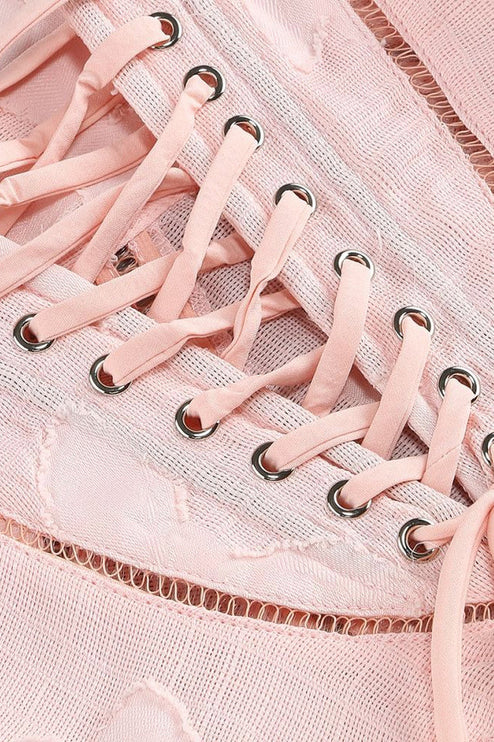 Detail of a pink floral maxi dress showcasing the corset lace-up back with silver eyelets and mesh fabric.