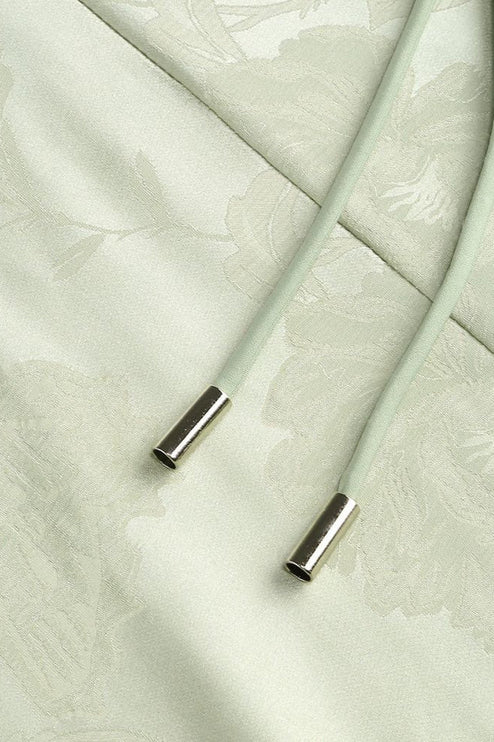 Detail of the light green floral maxi dress showing the ends of the corset laces with silver aglets.