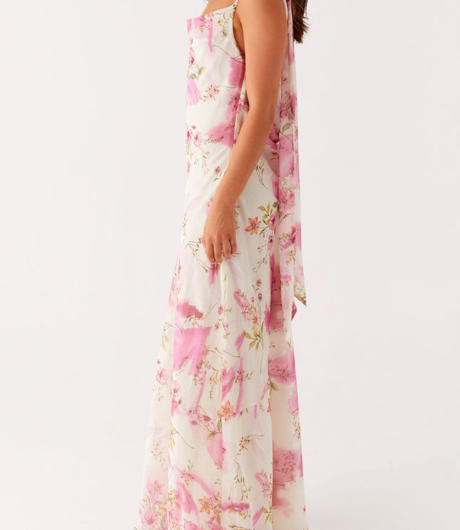 Side profile of a women's white floral maxi dress with pink and green pattern, showing the flowing fabric.