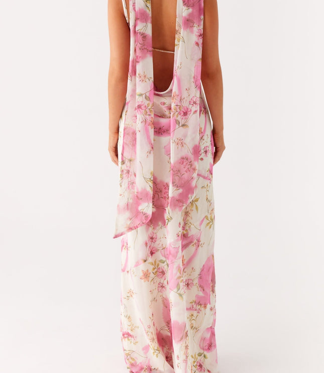 Back view of a women's white floral maxi dress with open back and long pink floral ties.