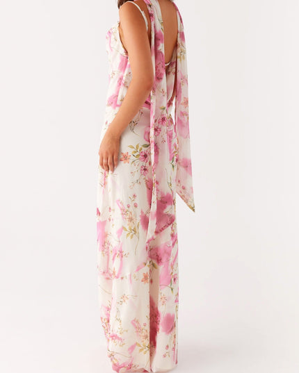 Three-quarter back view of a women's floral maxi dress, highlighting the open back and long draped ties.
