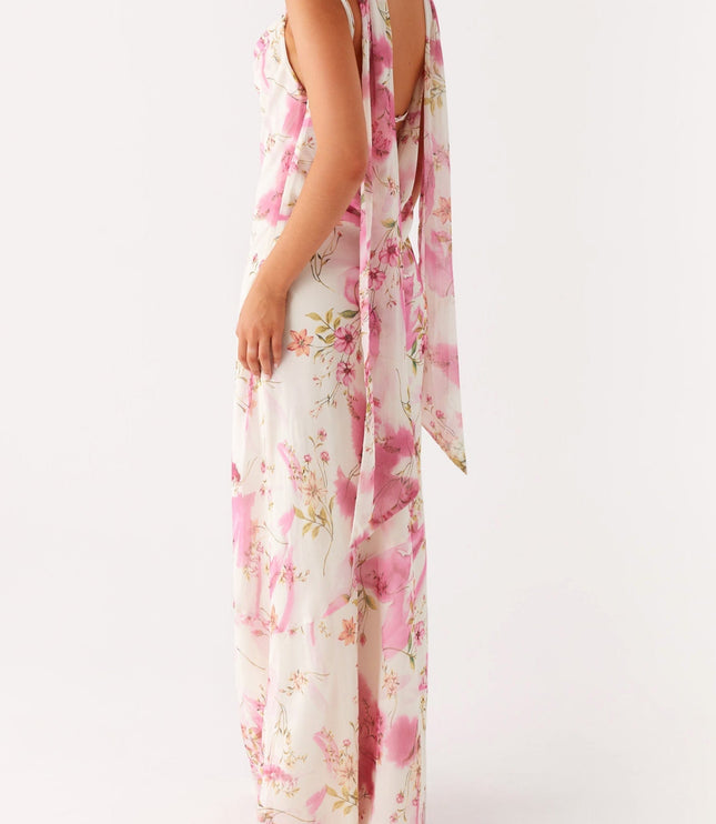 Three-quarter back view of a women's floral maxi dress, highlighting the open back and long draped ties.