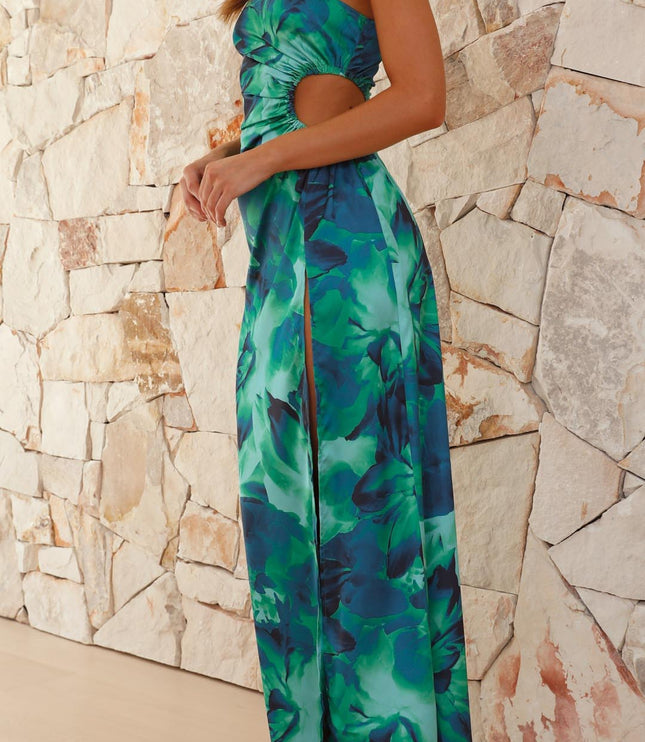 Women's floral print maxi dress in green and blue, showcasing the asymmetrical neckline and side slit, angled view.