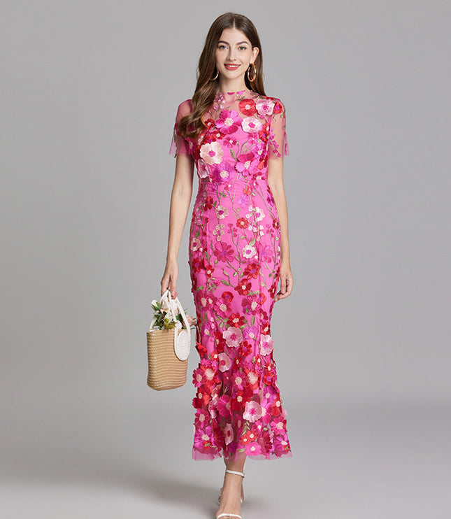 Full-length view of a women's vibrant pink floral embroidered sheer maxi prom dress with short sleeves and a basket.