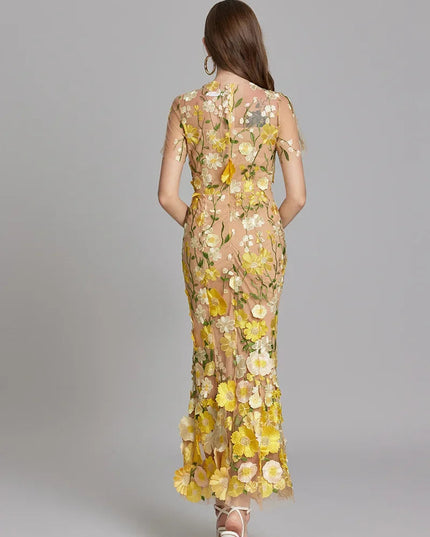 Back view of a women's yellow and white floral embroidered sheer maxi prom dress with short sleeves.