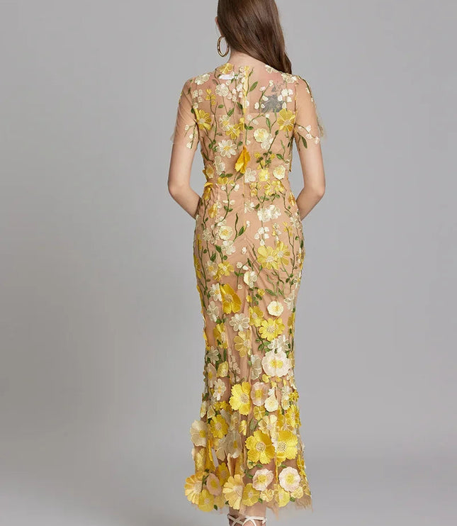 Back view of a women's yellow and white floral embroidered sheer maxi prom dress with short sleeves.