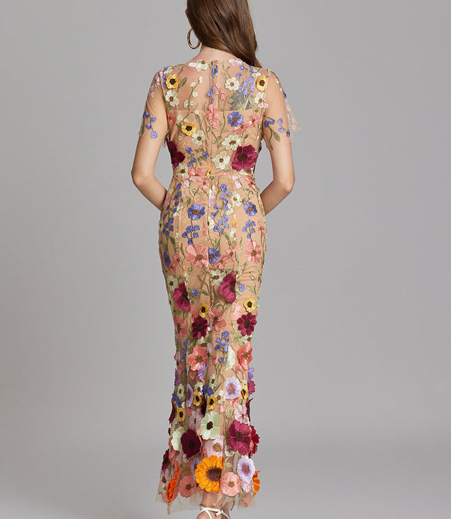 Back view of women's multi-color floral embroidered sheer maxi prom dress, short sleeves, showing floral pattern.