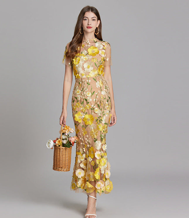 Full-length women's floral embroidered sheer maxi prom dress in yellow and white, short sleeves, holding a basket.