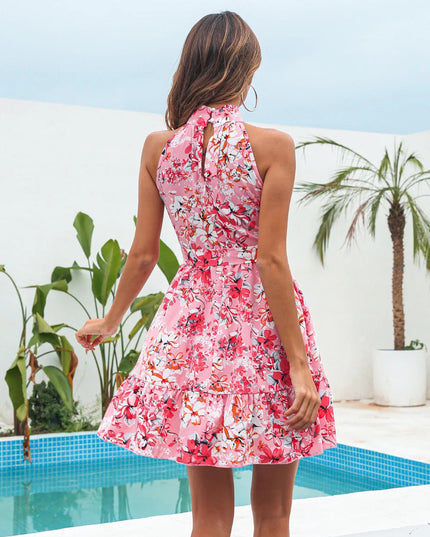 Back view of a pink floral halter neck tiered mini dress, showing the keyhole detail and flowing skirt, ideal for warm weather.